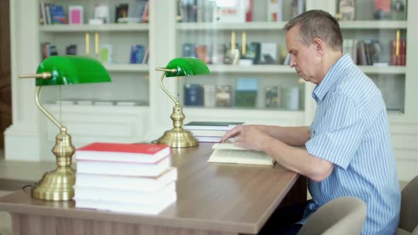 Senior Man with Mustache Reading a Book