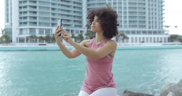 Cheerful Black Woman Taking Selfie on Seafront