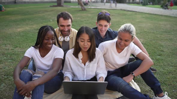 Joyful Students Chatting Online on Laptop Outdoors