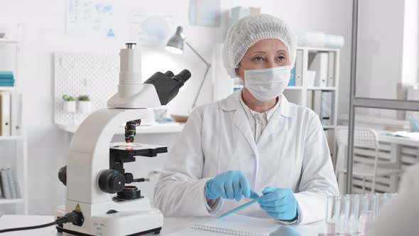 Laboratory Worker Looking through Microscope