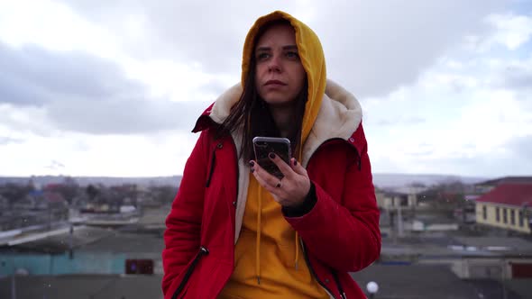 Portrait of Young Woman with Mobile Phone on Roof of Building