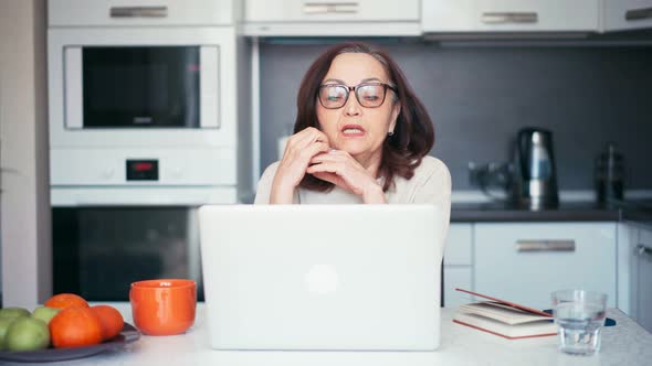 Senior Mature Older Woman Making a Business Training Online Webinar on a Laptop