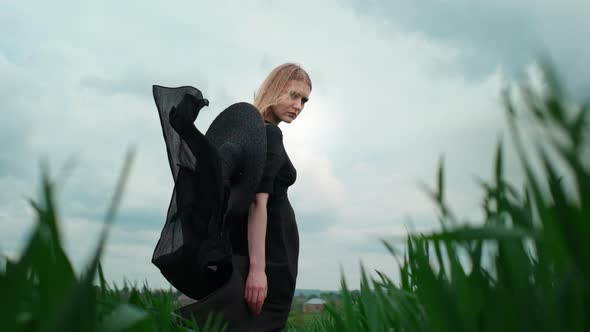 Flamboyant Girl In Black Dress Goes By The Field.