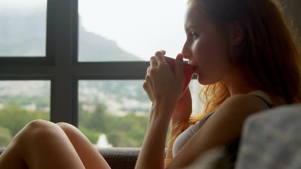 Woman having coffee in living room 4k