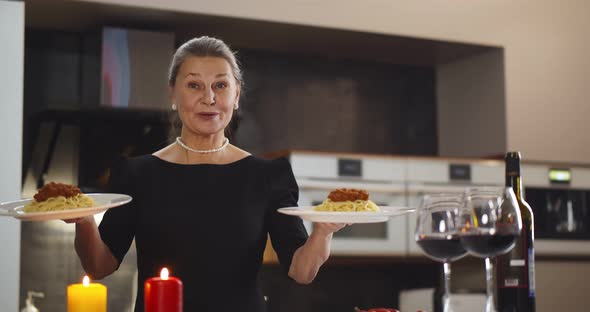 Happy Senior Woman Blogger Showing Cooked Pasta on Camera