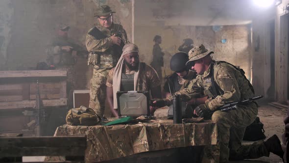 Soldiers Discussing Military Operation at Laptop