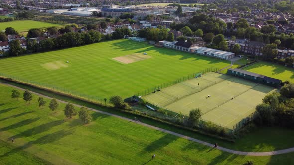 Aerial shot flying over a recreational park and sports ground in a British town