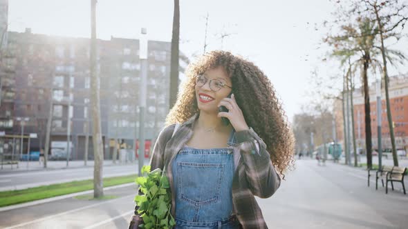Portrait of Happy African American Young Woman Talking with Cellphone in City