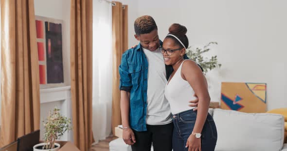 A Couple in Love Moves Into a New Apartment Cardboard Boxes with Packed Things Stand in the Living