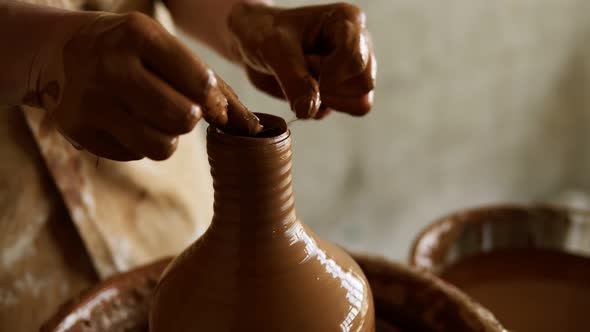 Female Potter Cuts Off Excess Clay on the Top of the Vase