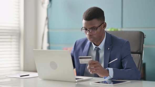 Young African Businessman Making Successful Online Payment on Laptop