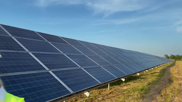 Professional Woman Worker Engineer Wearing a White Hard Hat Standing Near a Solar Farm Smiling at