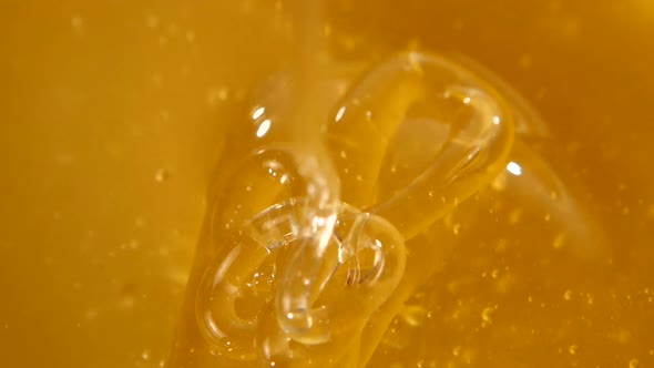 Using Spoon for Honey in Bowl, Flowing Down, Close Up