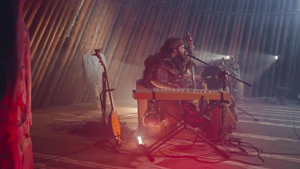 Man Plays Igil and Sings Old Fold Song on Stage with Logs