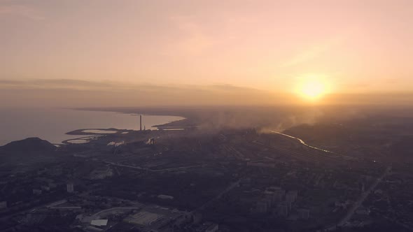 Sunset in Industrial City . On the Horizon, a Metallurgical Plant Near the Sea