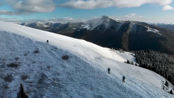 Flying Over a Group of Hikers Walking on a Mountain Ridge