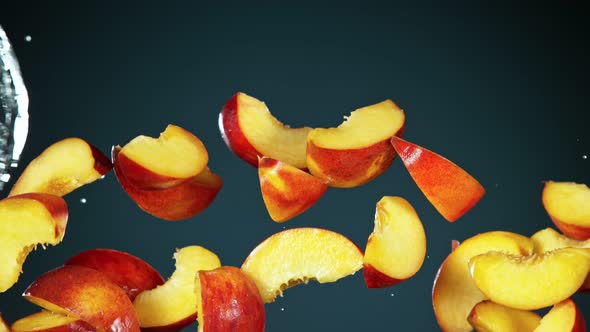 Super Slow Motion Shot of Flying Fresh Peach Slices and Water Side Splash at 1000Fps