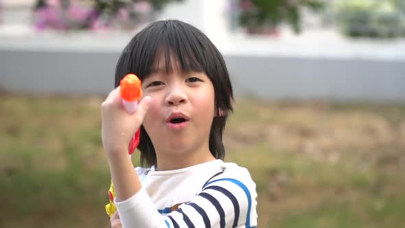 Cute Asian Child Playing With Water Gun In The Summer4