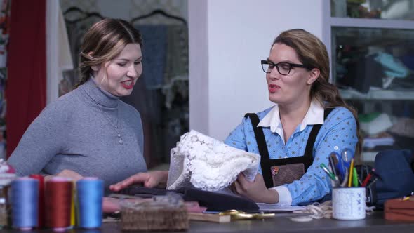 Female Tailor Showing To Client Sketches of Dress