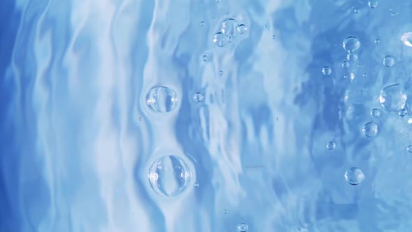 Top view slow motion of drop falling into the water surface and diverging circles on white backgroun