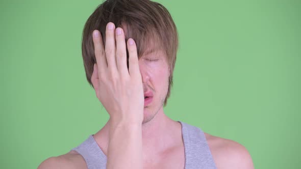 Face of Stressed Young Man with Messy Hair Showing Face Palm Gesture