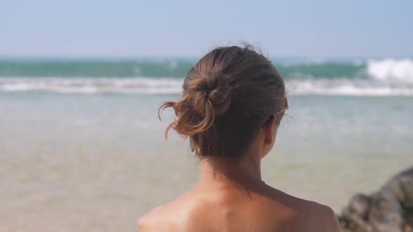 Slim Lady Wears Sunglasses and Observes Waving Ocean