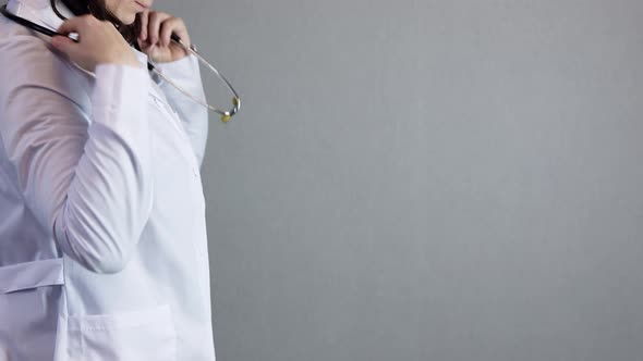 Unrecognizable Female Doctor White Uniform Putting Stethoscope Around Neck Grey