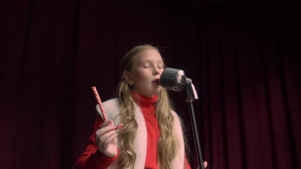 Girl Singing and Holding a Lollipop