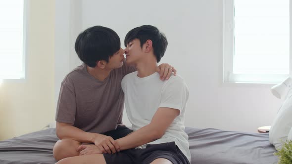 Asian Gay couple kissing on bed at home.