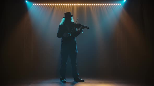 An Experienced Violinist Performing a Stunning Solo on Stage, Seen in the Light Against a Black