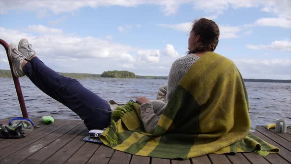 Young adult women girls relax on a lake dock.