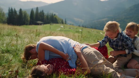 Family Lying Green Grass Piled on Each Other Sunny Day Parents Playing with Kids