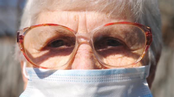 Detail Portrait of Granny in Protective Mask From Virus. Elderly Woman Looking Into Camera with