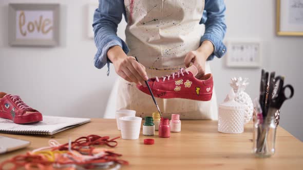 Entrepreneur Customizing Pair of Sneakers in Arts and Crafts Workshop