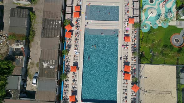 Drone Aerial View People Swim in Pool on Territory Modern Residential Complex