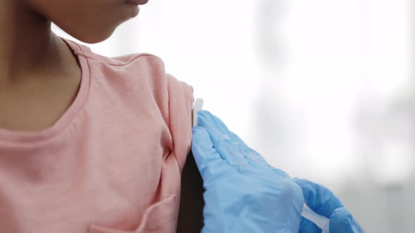 Close Up View of Doctor Hands in Protective Gloves Doing Inction of Vaccine in Arm of Little Girl