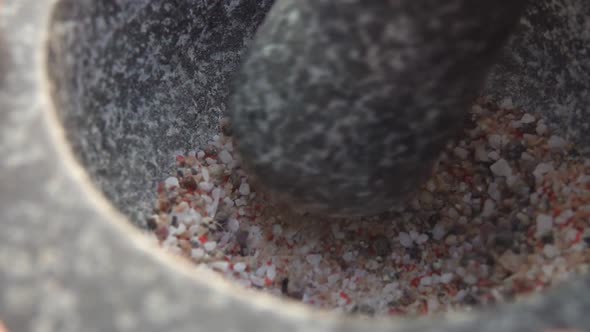 Heavy Pestle is Grinding a Mix of Spices Peppers and Sea Salt in the Mortar
