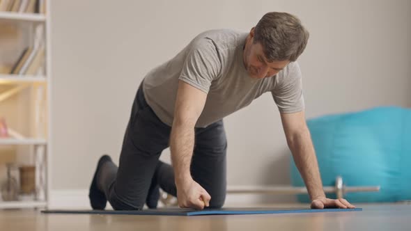 Camera Follows Confident Positive Caucasian Man Taking Sport Position for Pushups and Start