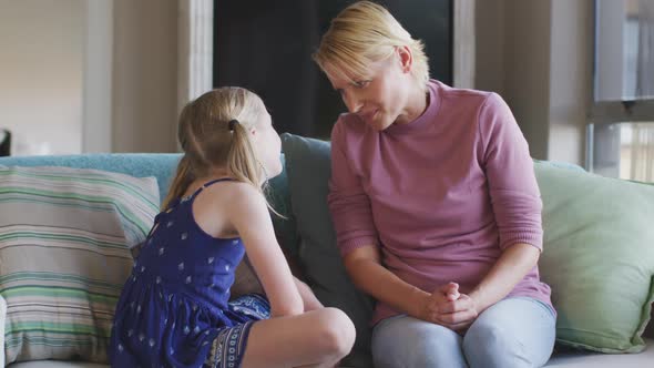 Caucasian woman talking with her daughter at home