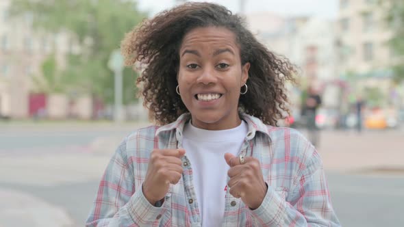 Portrait of Excited African Woman Celebrating Success Outdoor