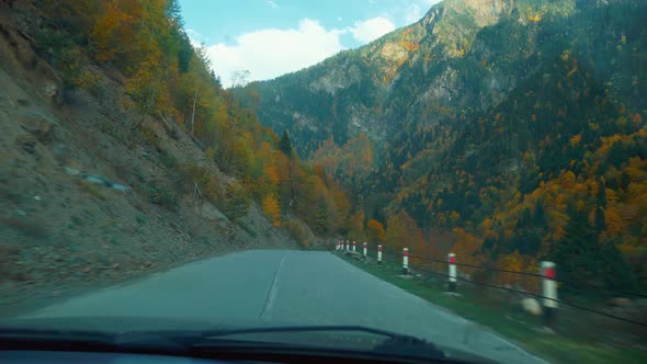 camera shoots from first person, car is driving along a narrow mountain road.