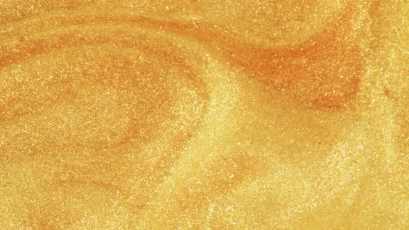 Colorful Golden Sand Organically Moves in Colorful Liquid in Macro alt