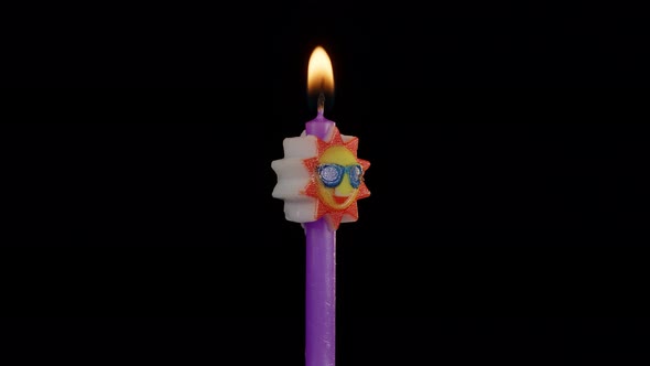 Birthday Festive Candle in Form of Sun in Sunglasses Turning Spinning Isolated on Black Background