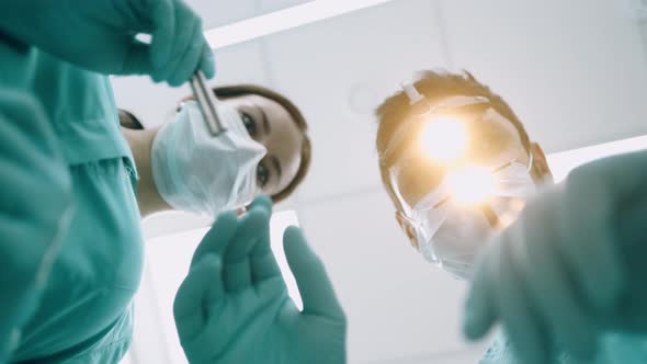 At the Dentist. Handsome Young Dentist in Surgical Mask Is Holding Tools and Looking at Camera