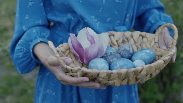 Close up cinematic shot of a girl holding in hands basket with easter eggs isolated on bright green