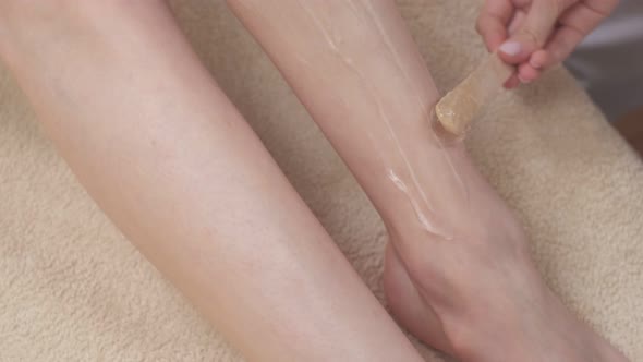 Depilatory Gel Being Applied on Woman's Legs By Stick