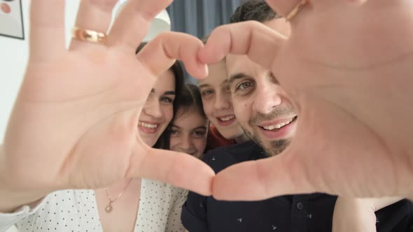 Happy Family Dad Mom and Children Make a Hand Gesture in the Shape of a Heart
