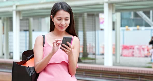 Asian woman use of mobile phone in the city