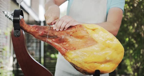 A Man Starts Cutting the Whole Jamon Leg