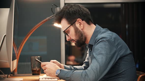 Overtime Work In Office. Businessman Talking On Phone In Modern Office.Businessman Working In Office